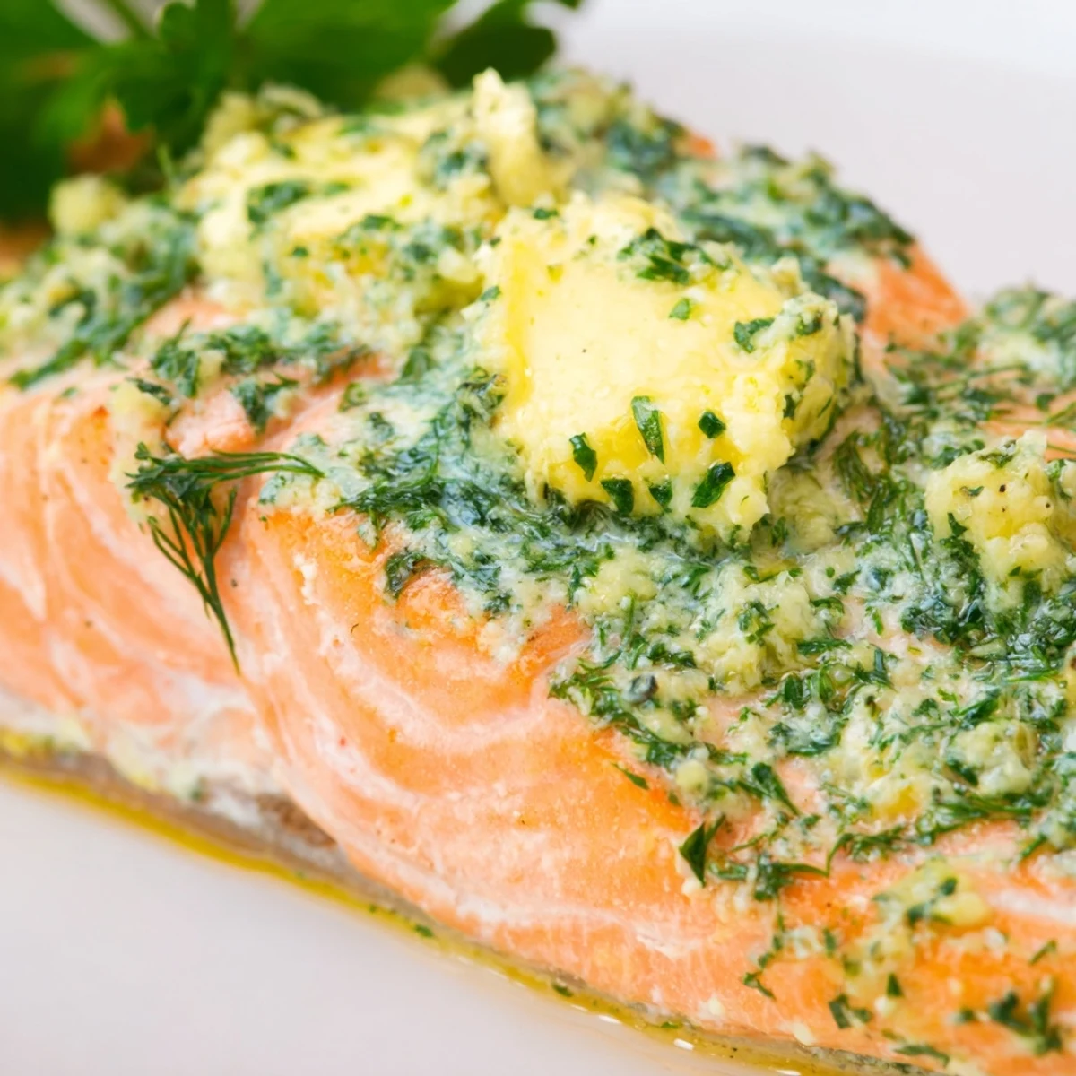 A close-up of Baked Salmon with Lemon Herb Butter, showcasing the melting butter sauce and bright citrus zest.