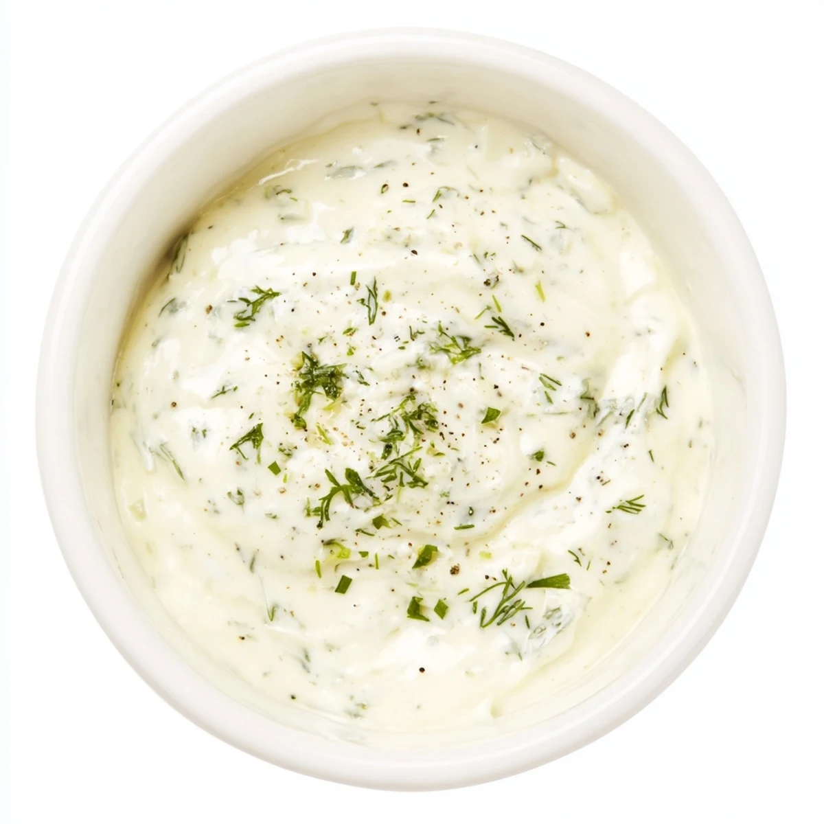 A glass jar of Creamy Salad Dressing with Herbs sits beside a vibrant mixed green salad with cherry tomatoes and cucumbers.