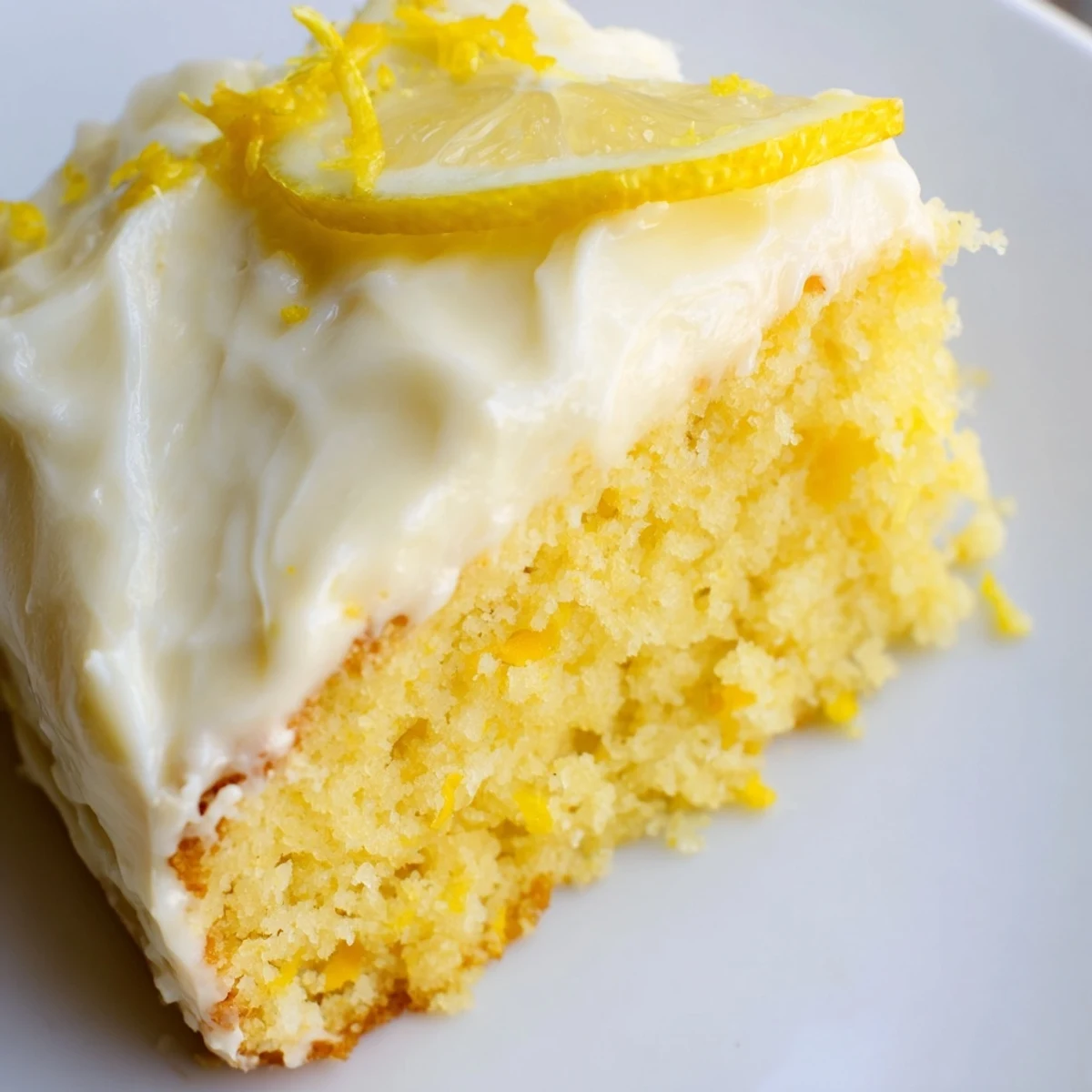 A single slice of Lemon Cake with Frosting, revealing its tender crumb and creamy lemon topping on a rustic plate.
