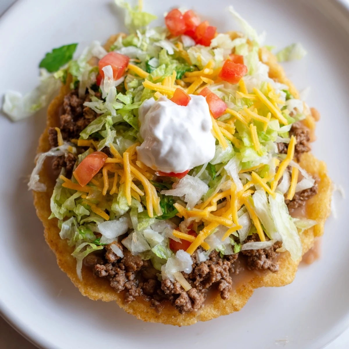 Sizzling Mexican-style beef and creamy beans top crispy tostadas, garnished with crisp lettuce, cheese, and zesty lime wedges.