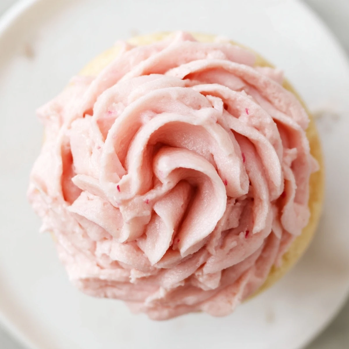 Twelve fluffy Valentine Pink Champagne Cupcakes topped with creamy pink buttercream sit on a white plate, ready for celebration.