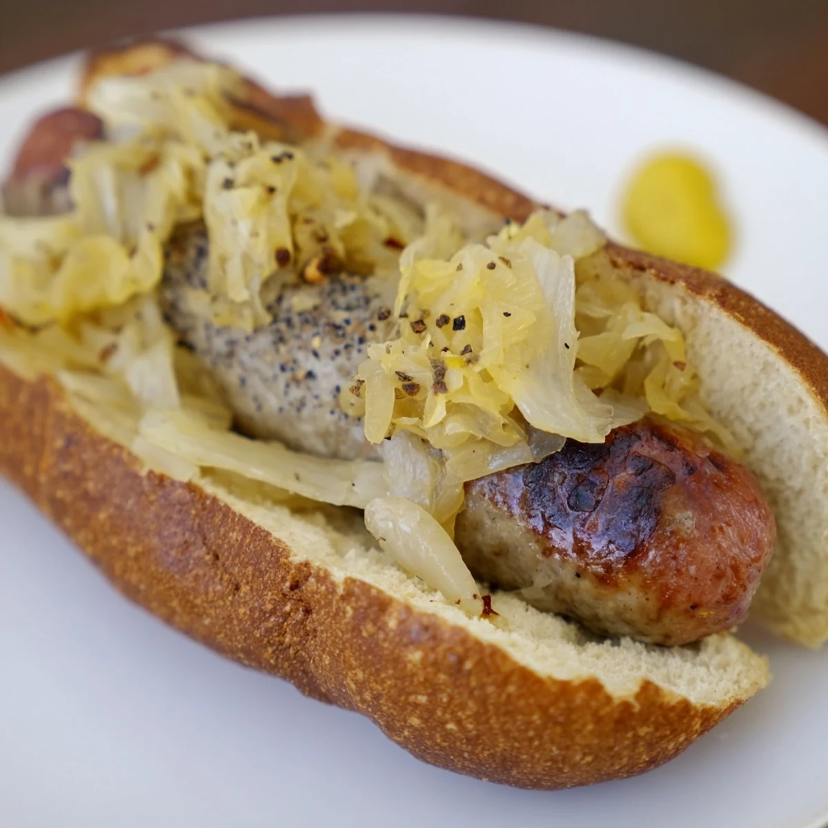 Golden-brown Tailgate Bratwurst with Sauerkraut rests on a paper-lined tray, ideal for a game-day crowd.