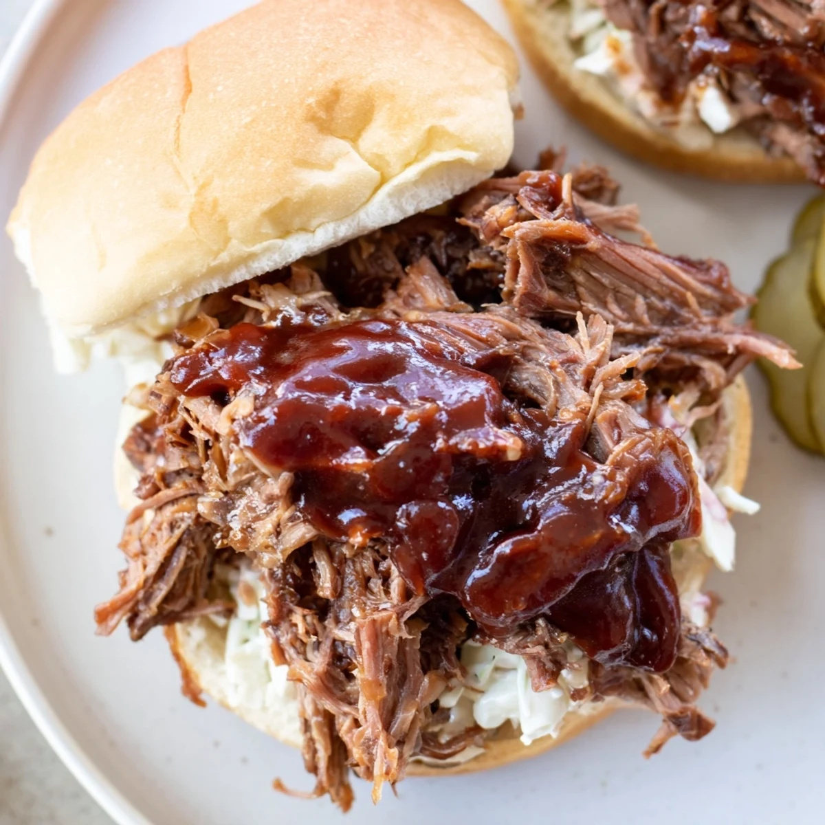 Golden BBQ beef brisket sliders resting on a wooden board, garnished with pickles and coleslaw, perfect for casual American gatherings.