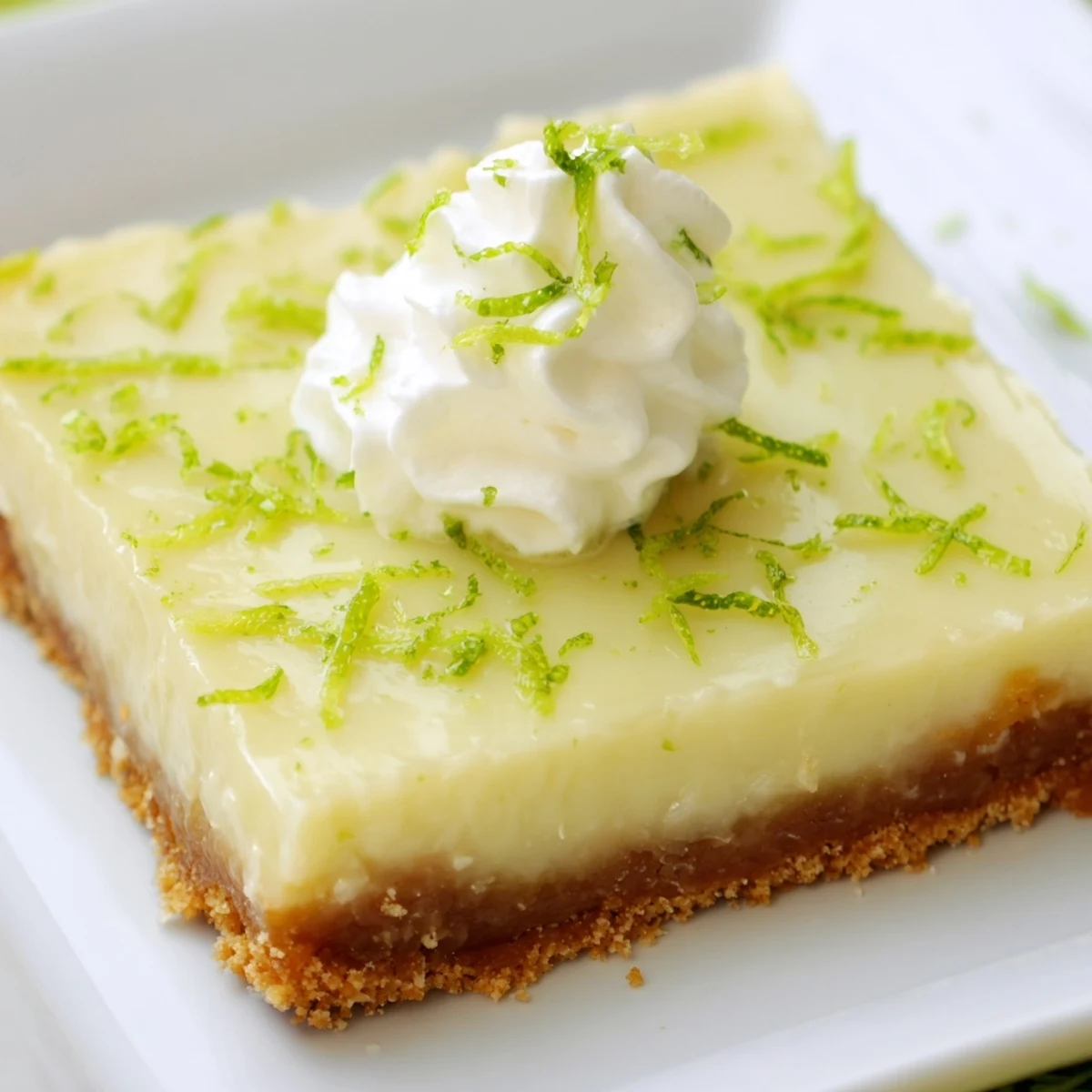 Ready-to-serve Key Lime Pie Bars garnished with whipped cream and lime slices, perfect for a summer dessert party.