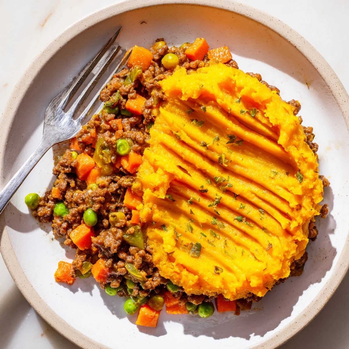 Beef Shepherds Pie with Sweet Potato Topping, featuring a fork-riddled crust and steam rising from the golden top.