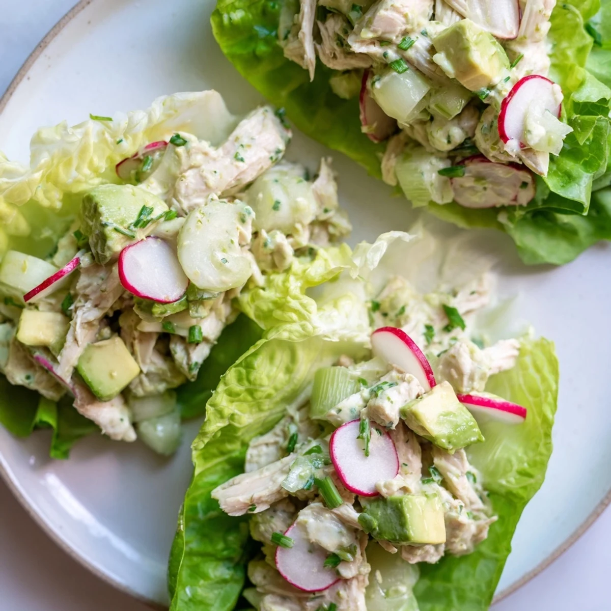 Spoonful of vibrant Green Goddess Chicken Salad Lettuce Wraps featuring tender chicken and diced avocado for a healthy low carb meal.