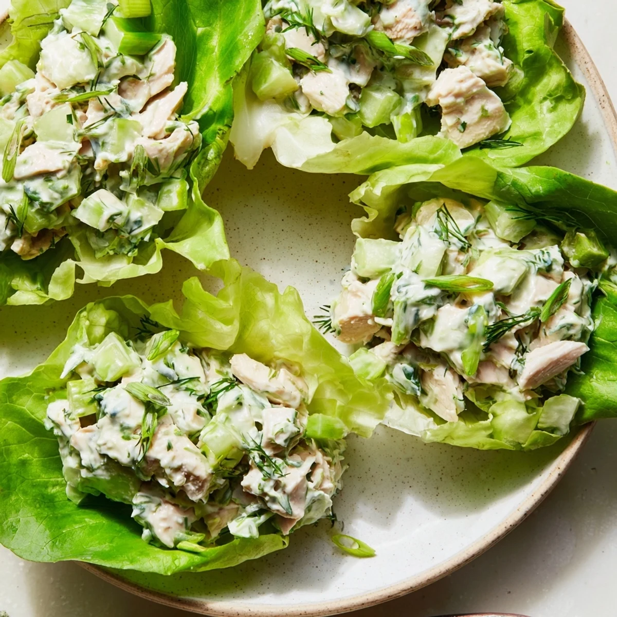 Freshly roasted chicken salad with Green Goddess dressing spooned into crisp butter lettuce wraps, garnished with herbs.