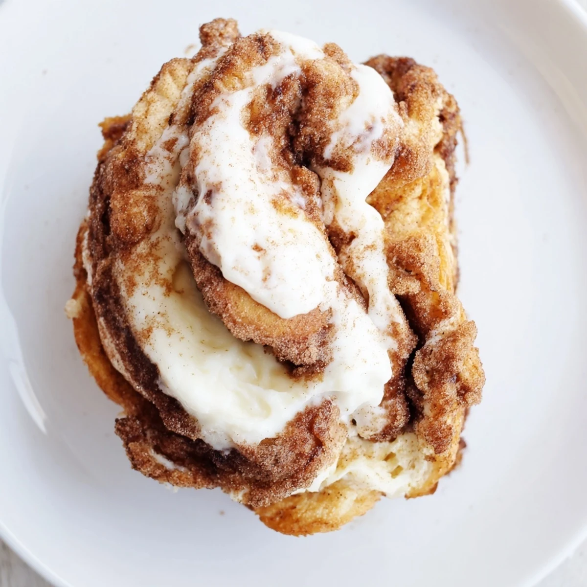 Golden-brown Keto Cinnamon Buns with swirls of cinnamon filling arranged in a round baking pan.