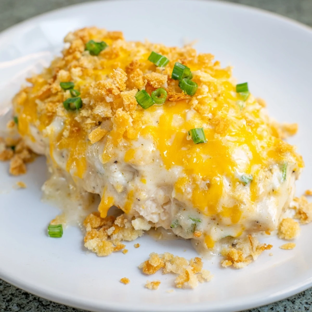 Savory Sour Cream and Onion Chicken breasts topped with crunchy chips, resting in a bubbly sauce.