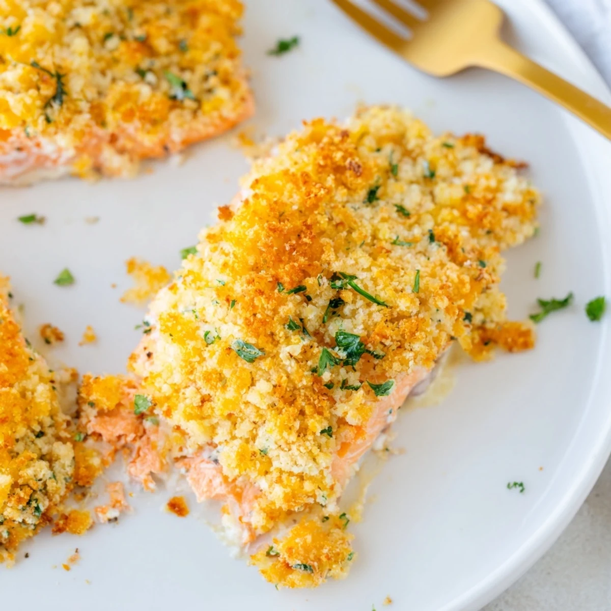 Baked salmon fillet with a crunchy, buttery panko and Parmesan crust, ready to serve with steamed asparagus and lemon.