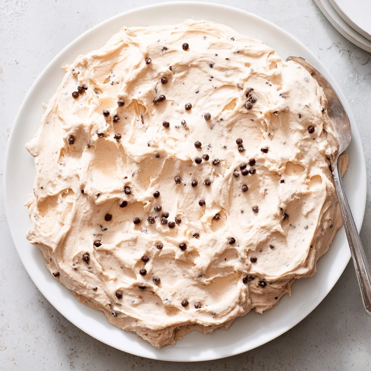 A bowl of Cookie Dough Frosting with softened butter, brown sugar, and chocolate chips for a rich, cookie-like topping.