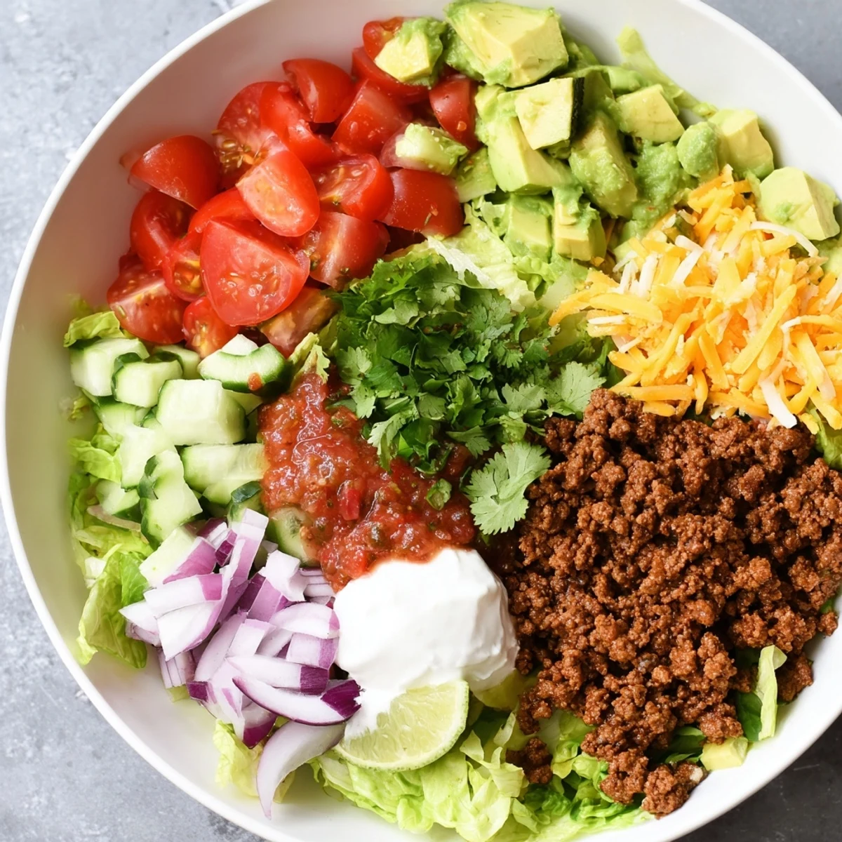Spicy Low Carb Burrito Bowl featuring juicy meat, crunchy cucumbers, and a lime wedge for a zesty Mexican-inspired finish.
