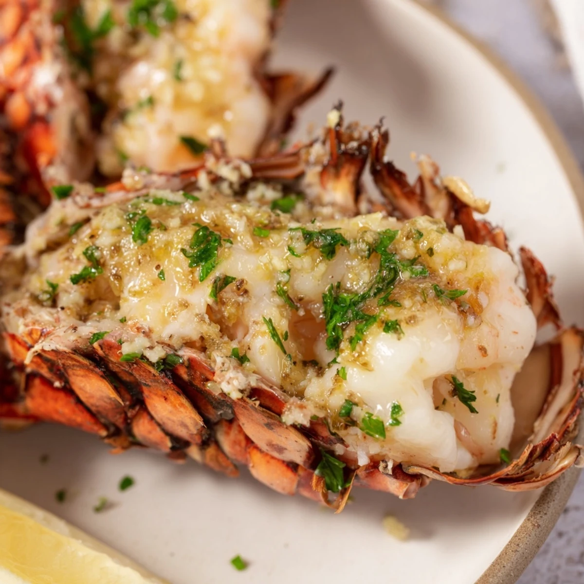 Smoked Lobster Tails With Garlic Butter glistening with rich butter and herbs on a platter.