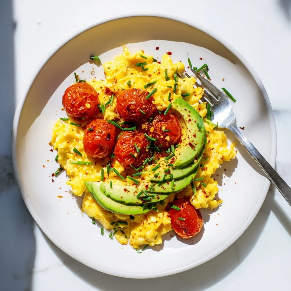 Scrambled Eggs With Avocado Seared Tomato Delight served warm alongside toasted whole grain bread slices.