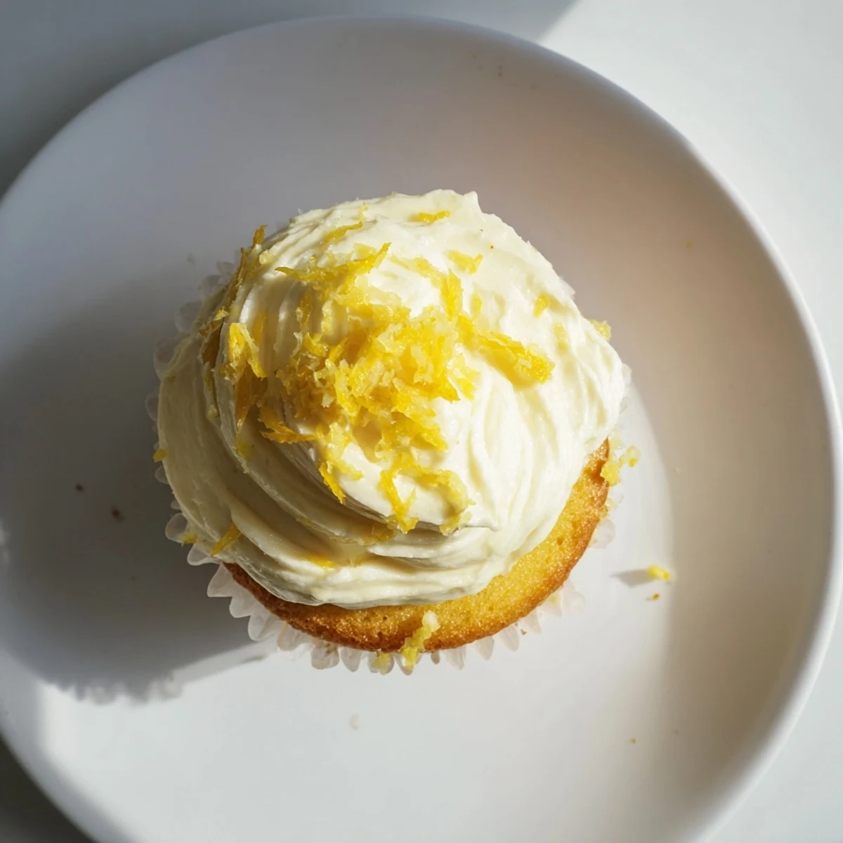Moist Limoncello Cupcakes with zesty lemon crumb, topped with creamy Limoncello frosting on a pastel platter.  