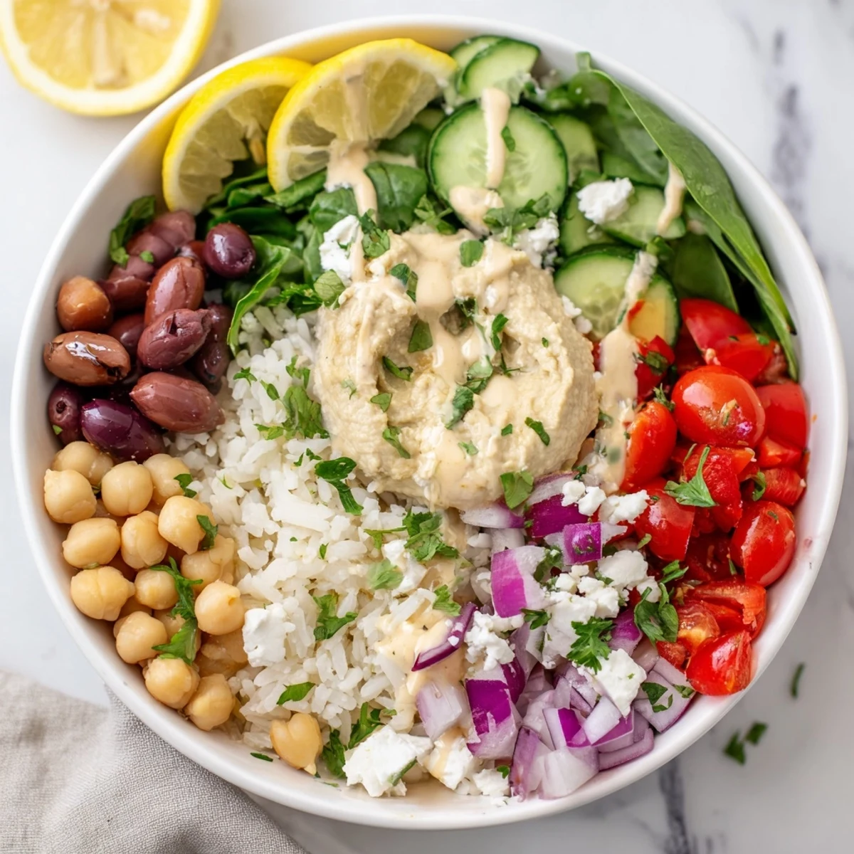 Colorful Mediterranean rice bowl topped with fresh vegetables, chickpeas, hummus, and tangy feta cheese