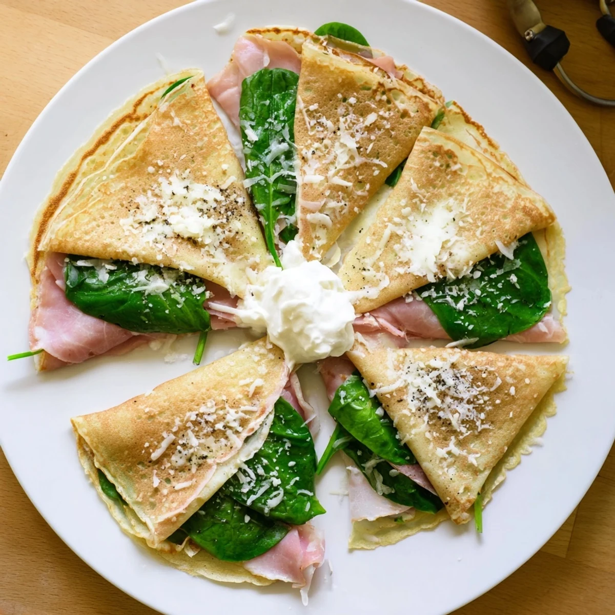 Golden savory crepes filled with melted Gruyère cheese, ham, and fresh baby spinach