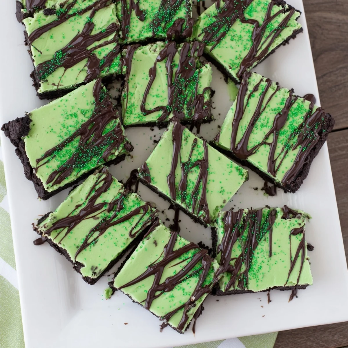 Decadent St. Patricks Irish Mint Cheesecake Fudge Squares on chocolate cookie crust with dark chocolate drizzle