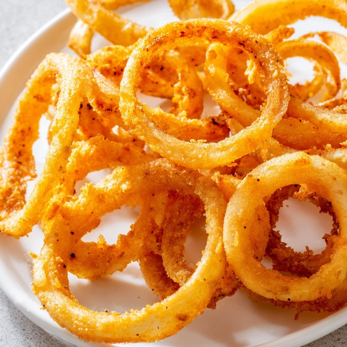 Stack of ultra-thin onion ring chips garnished with fresh parsley ready for snacking