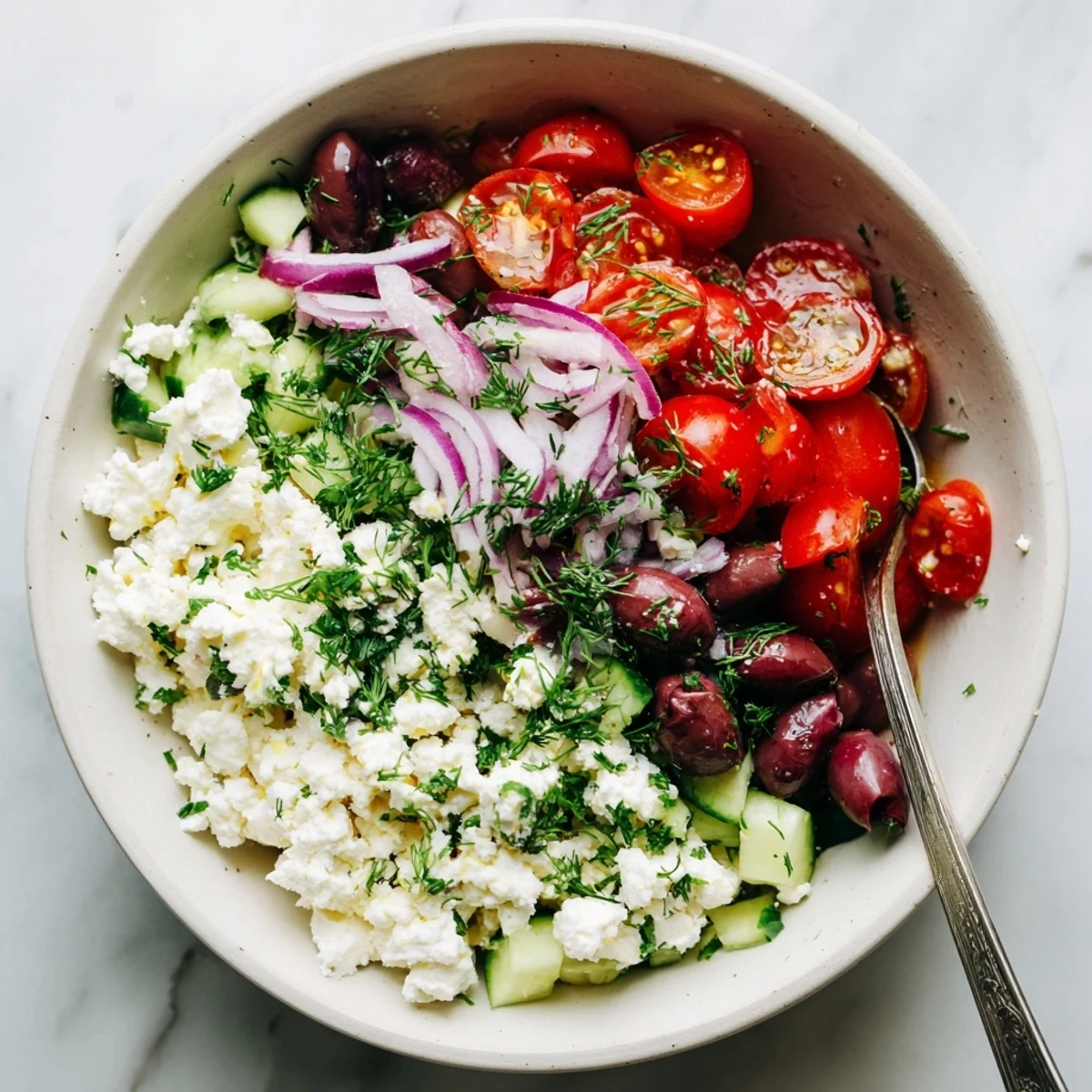 Fresh cottage cheese bowl layered with Mediterranean vegetables and tangy feta cheese for a protein-rich lunch
