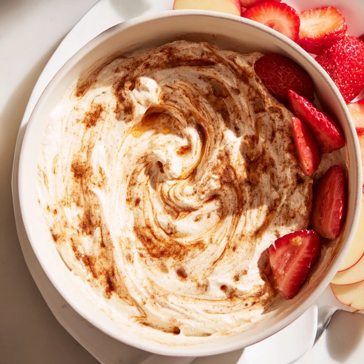 Healthy yogurt-based dessert dip drizzled with sweet cinnamon mixture arranged with fresh pear slices and banana for easy snacking