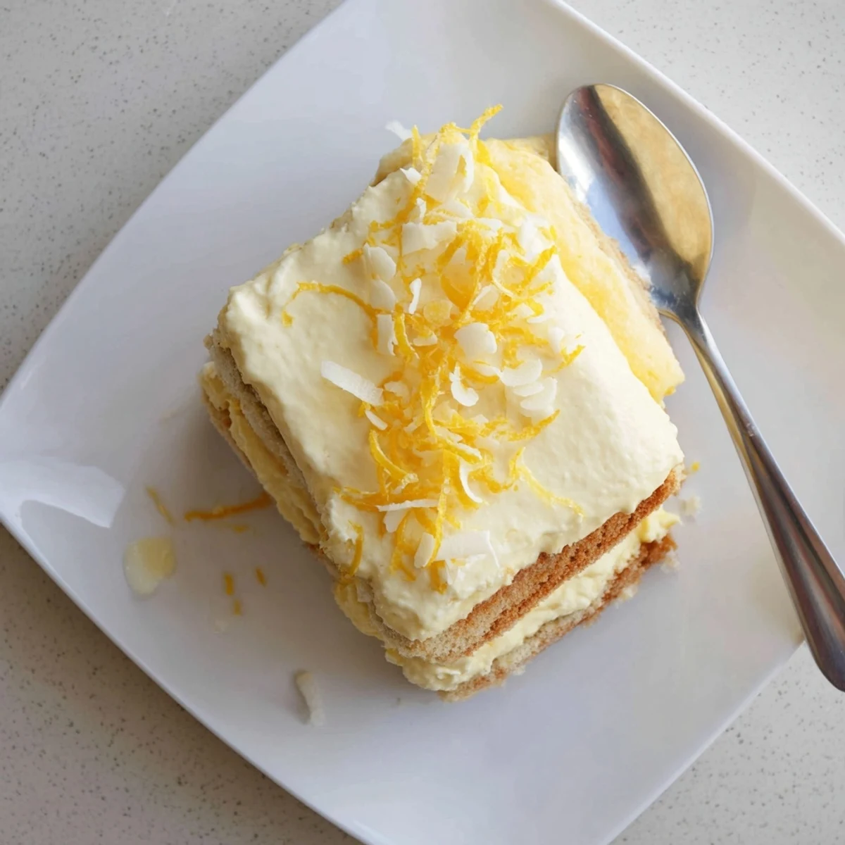 Creamy lemon tiramisu layered with syrup-soaked ladyfingers and bright lemon zest
