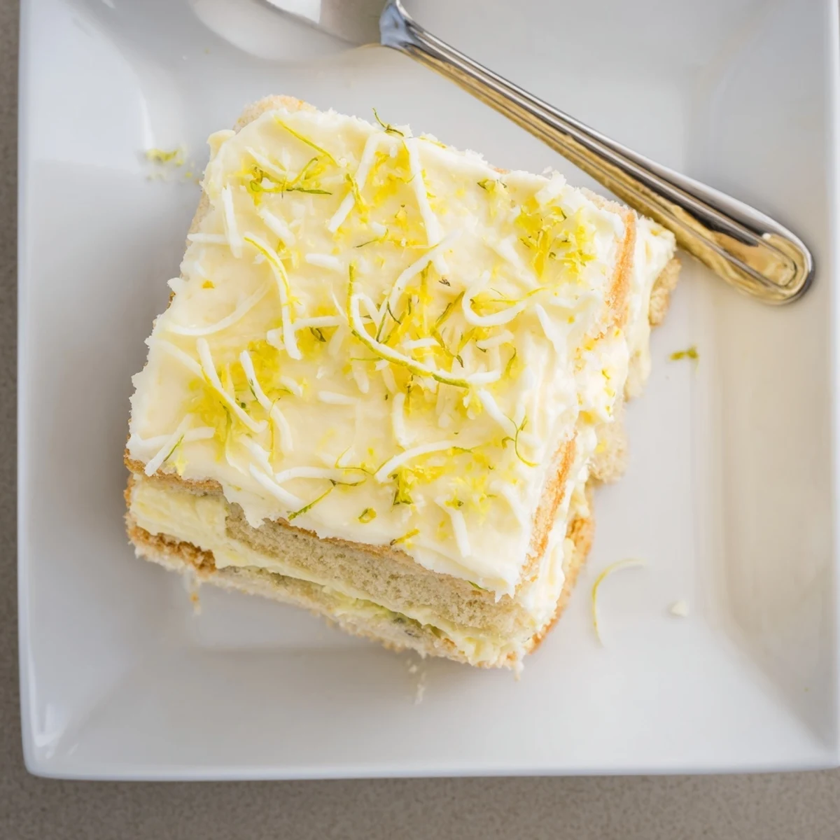 Tangy lemon tiramisu cross-section revealing fluffy mascarpone cream and golden soaked biscuits