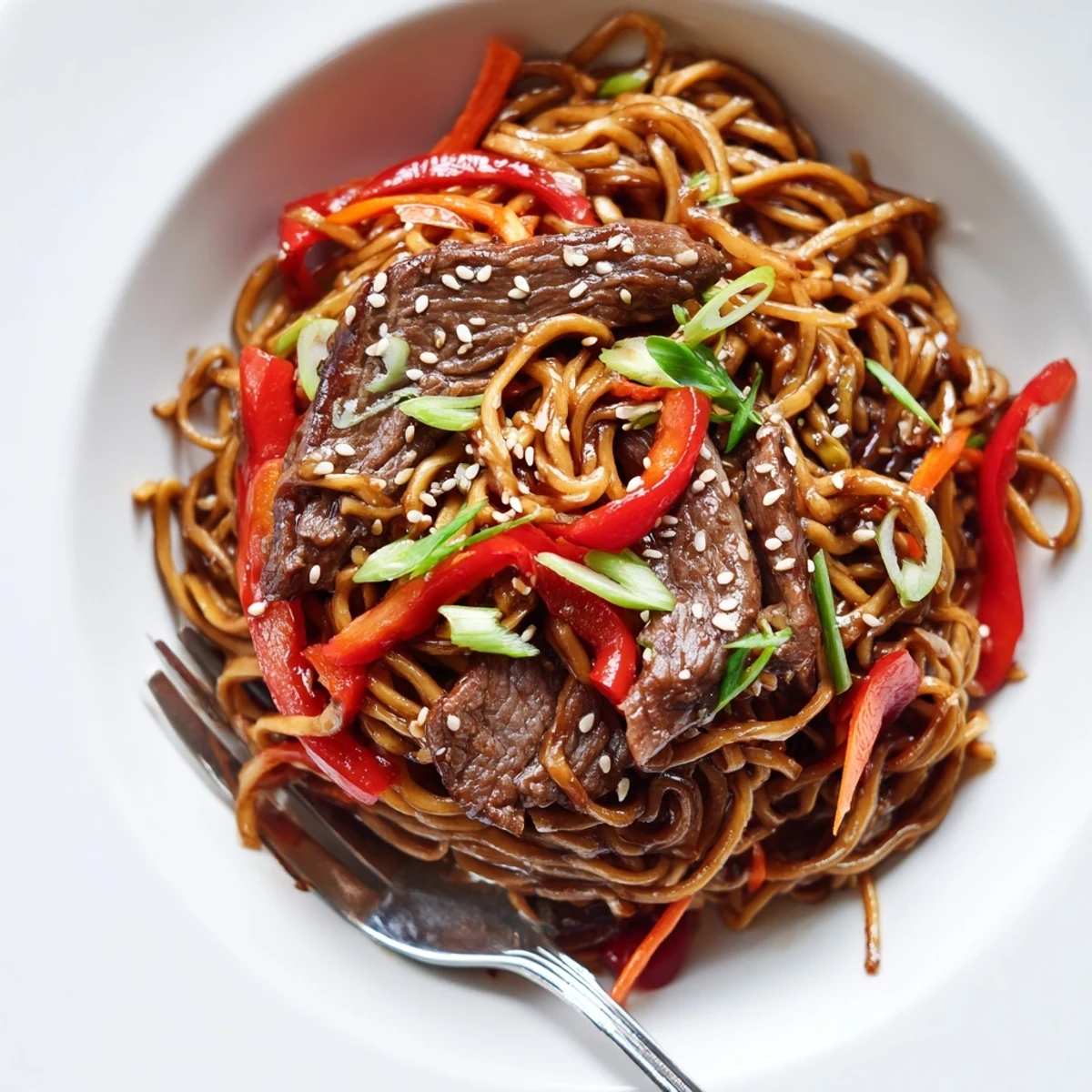 Sticky Beef Noodles glisten with glossy sauce, tender beef and sesame garnish