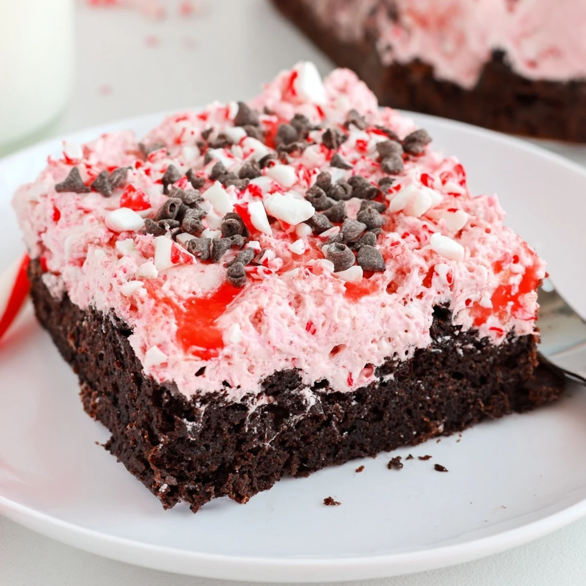 Slice of Peppermint Poke Cake showing pudding-filled holes and minty crumbs