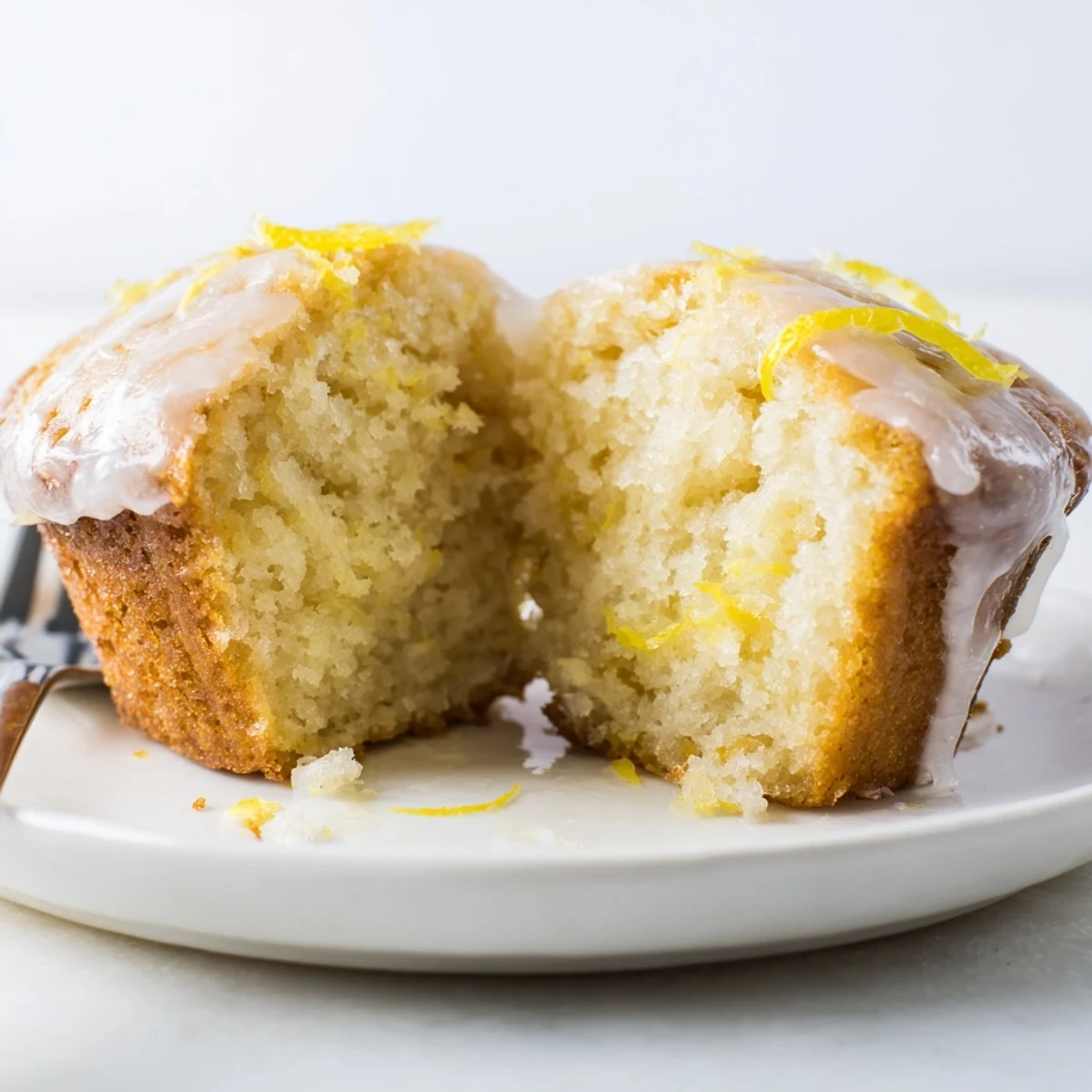 A plate of Glazed Lemon Ginger Muffins, tender crumb and tangy glaze.