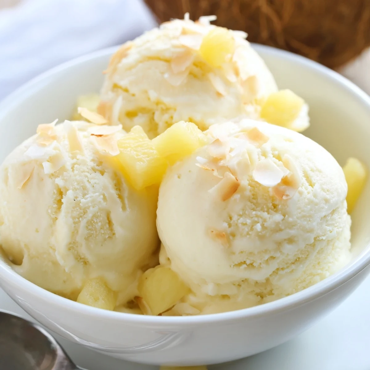 Silky Creamy Pineapple Ice Cream spoonful in bowl, cool tropical sweetness