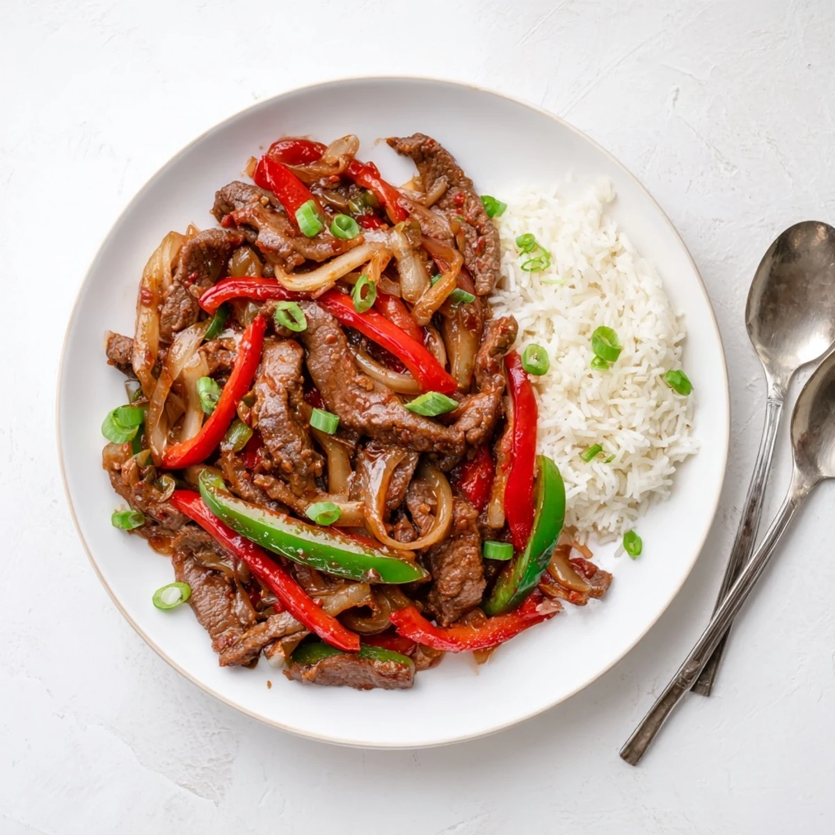 Golden slices of beef and colorful bell peppers coated in spicy chili garlic sauce