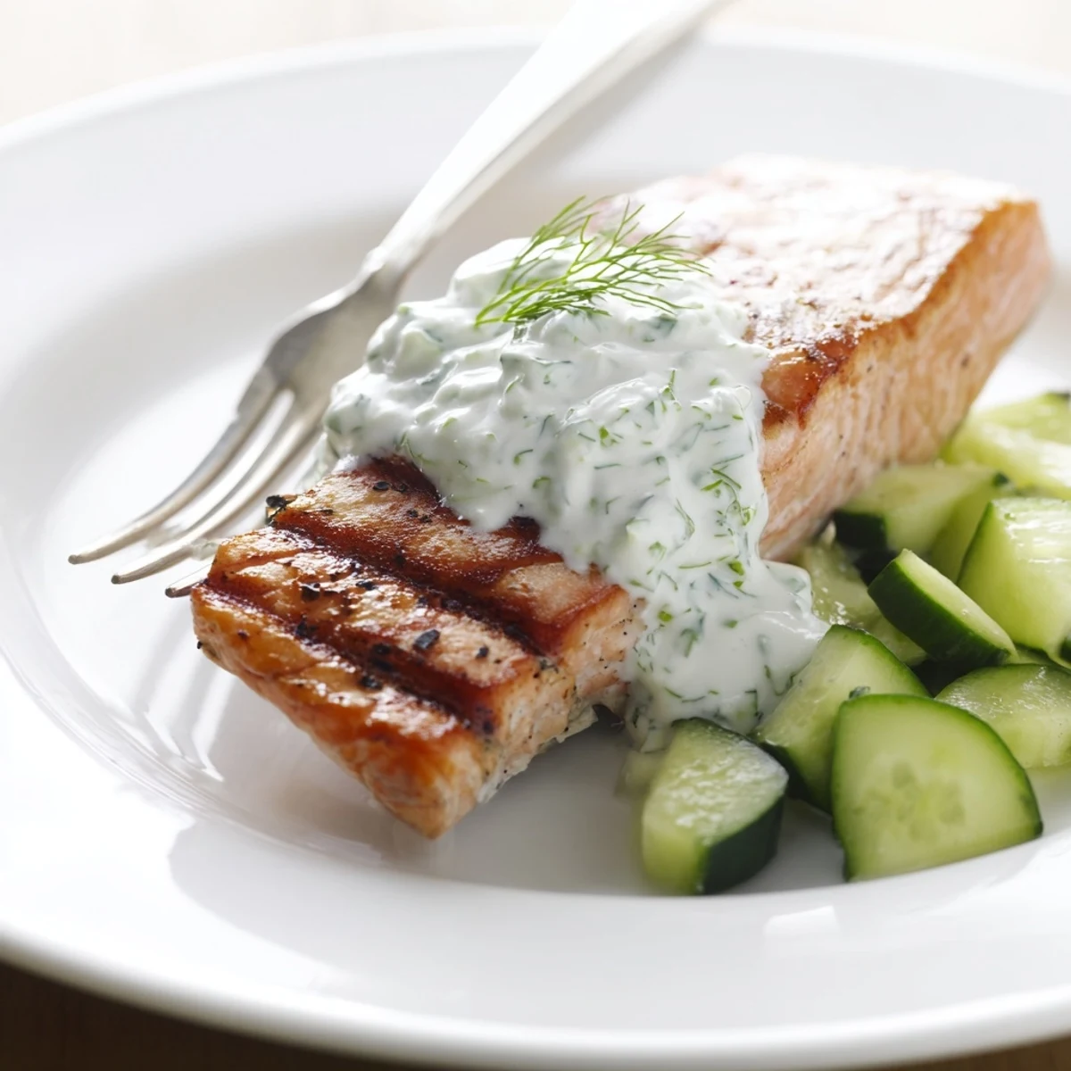 Juicy grilled salmon with bright citrus flavor garnished with fresh dill and refreshing cucumber sauce