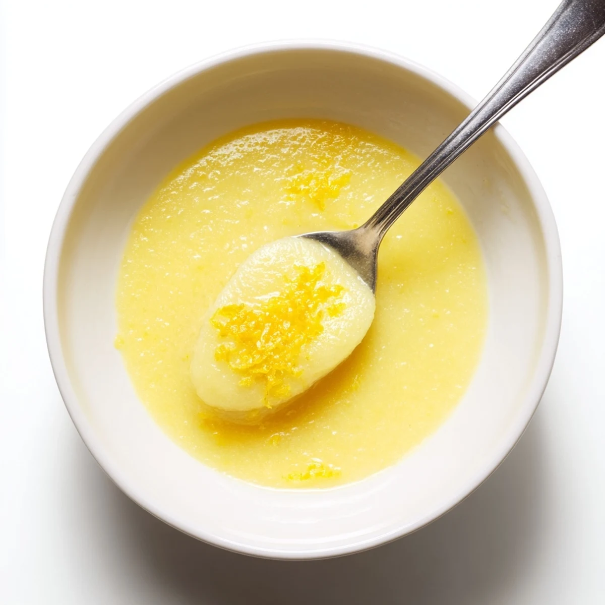 Homemade Lemon Curd glossy and tangy in jar, spooned over scones