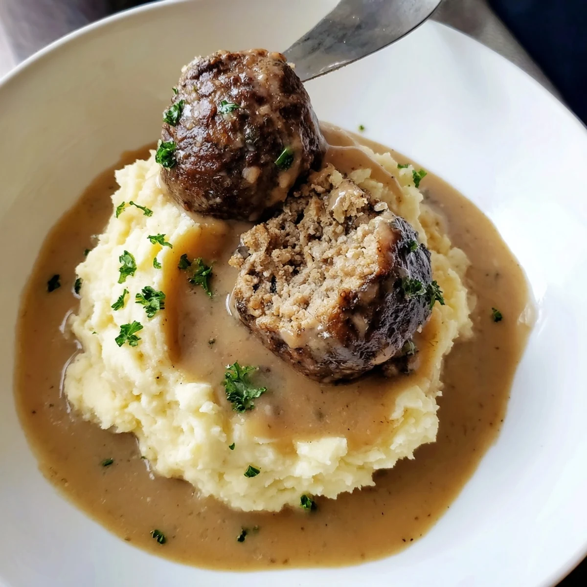 Crockpot Meatballs Gravy bubbling over mashed potatoes, tender beef and savory aroma.
