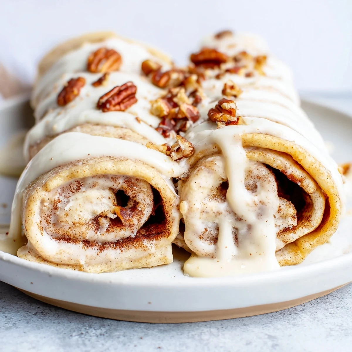 Golden Cinnamon Roll Protein Crepes filled with creamy cinnamon swirl and rolled tight