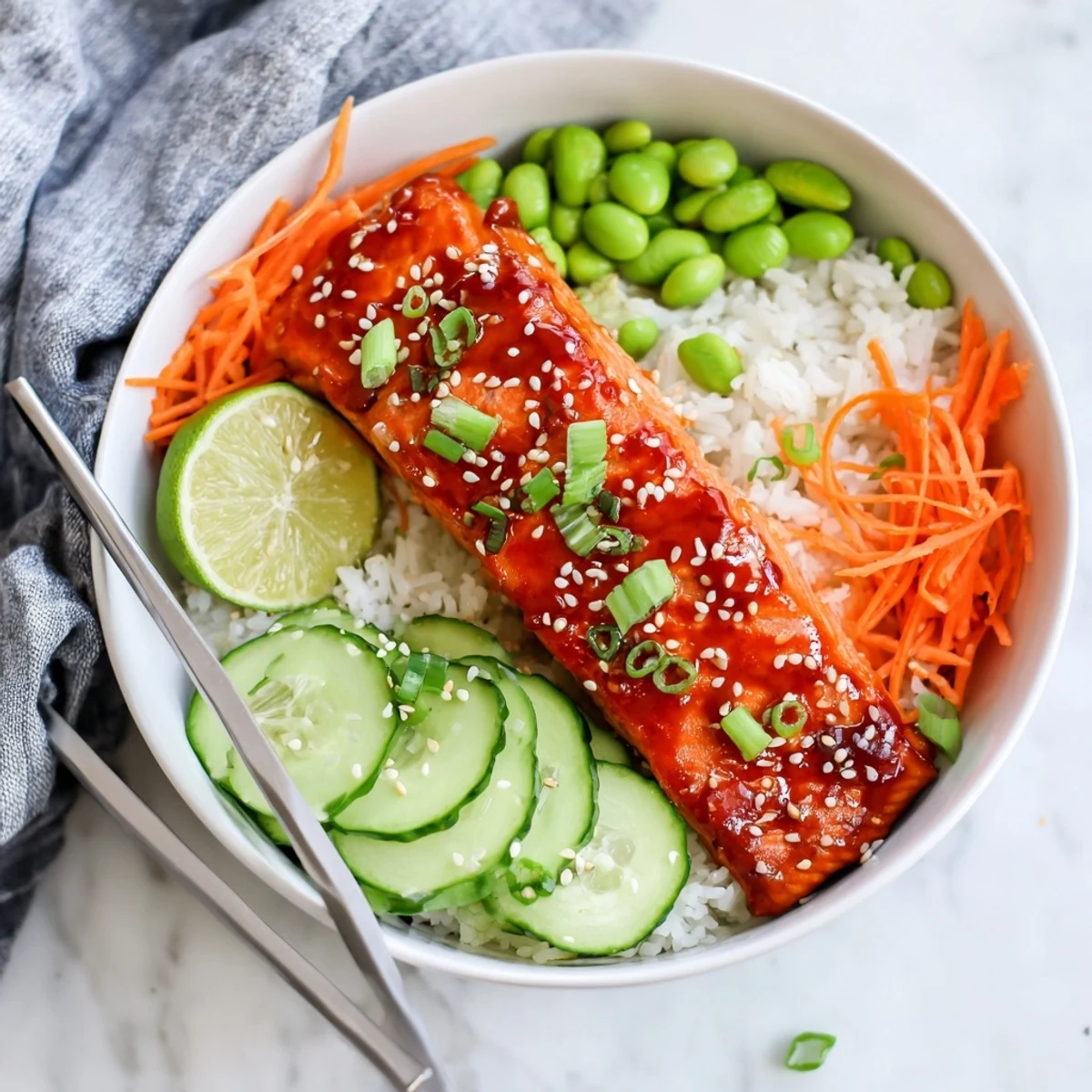 Glossy sriracha honey glazed salmon fillets resting on steamed rice with colorful vegetables
