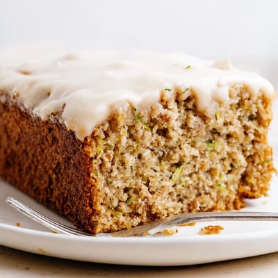 A fork-ready Zucchini Cake With Brown Sugar Icing, nutty texture and buttery glaze