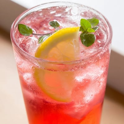 Chilled honey lemon pink soda in ice-filled glasses sparkling at a summer table